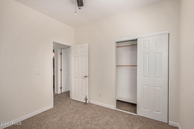 unfurnished bedroom featuring carpet, ceiling fan, and a closet