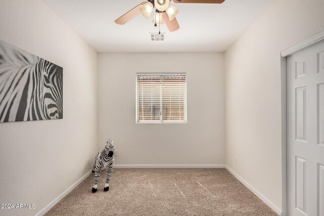 carpeted spare room with ceiling fan