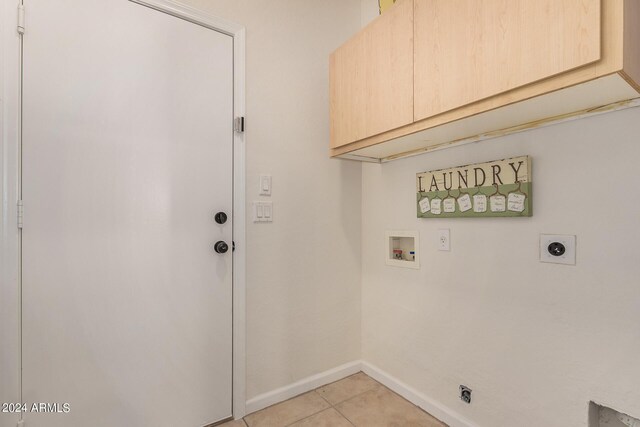 laundry room featuring hookup for an electric dryer, cabinets, light tile patterned floors, and hookup for a washing machine