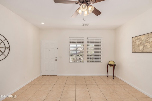 tiled empty room featuring ceiling fan