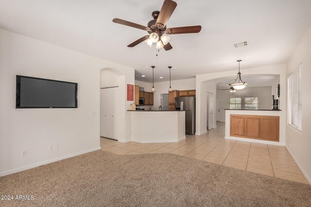 unfurnished living room featuring ceiling fan and light tile patterned flooring