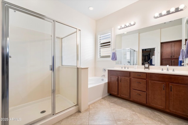 bathroom featuring a garden tub, double vanity, a stall shower, a sink, and tile patterned floors