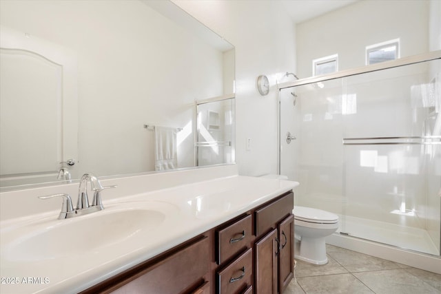 bathroom featuring vanity, a shower stall, toilet, and tile patterned floors