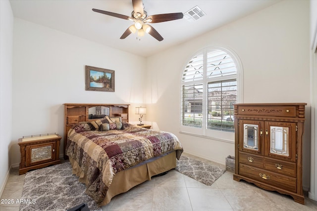 bedroom featuring baseboards, visible vents, ceiling fan, and light tile patterned flooring