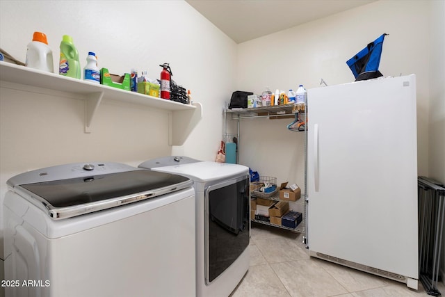 laundry area with light tile patterned floors, laundry area, and washing machine and dryer