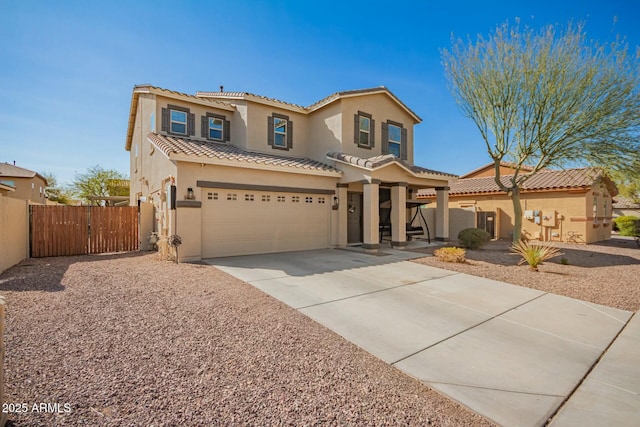 mediterranean / spanish-style home featuring a garage, fence, driveway, a tiled roof, and stucco siding