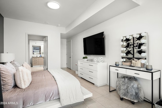 bedroom with ensuite bath and light tile patterned floors