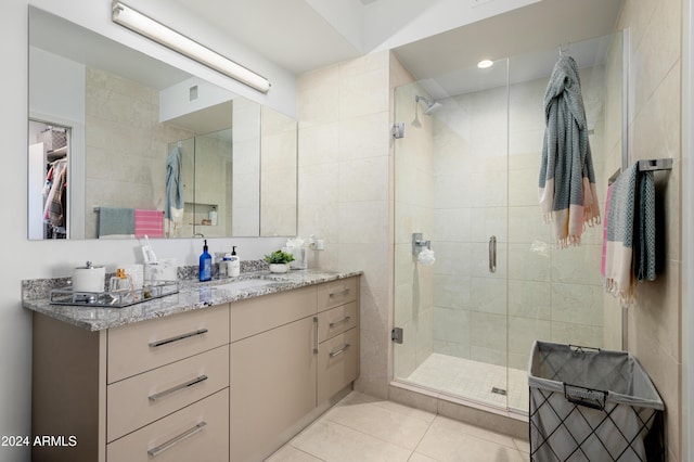 bathroom featuring a stall shower, tile patterned floors, a walk in closet, and vanity