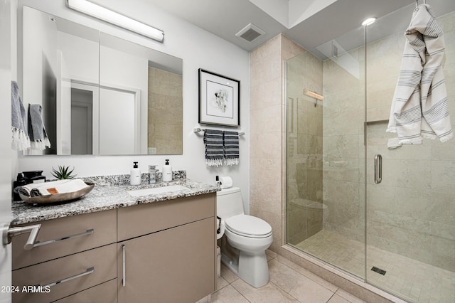 bathroom with toilet, visible vents, vanity, a shower stall, and tile patterned floors