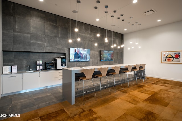 bar featuring a sink, tasteful backsplash, visible vents, and indoor wet bar