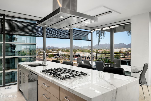 kitchen with light tile patterned floors, island range hood, stainless steel gas cooktop, a sink, and modern cabinets