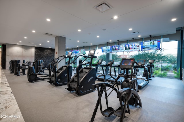 gym with a wall of windows, visible vents, and recessed lighting