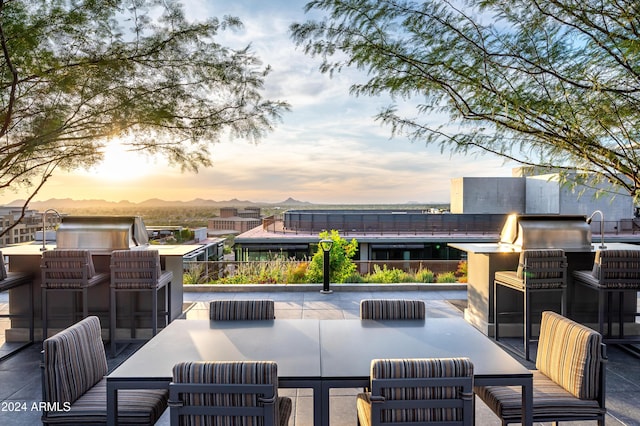 patio terrace at dusk featuring an outdoor kitchen