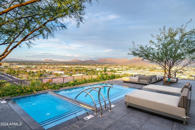 outdoor pool with a patio, outdoor lounge area, and a mountain view