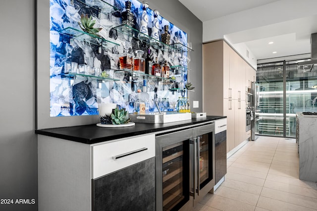 bar featuring beverage cooler, a dry bar, light tile patterned flooring, and stainless steel oven