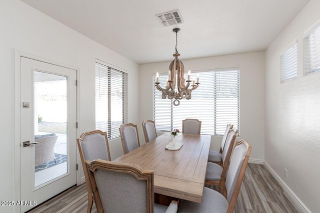 dining room featuring an inviting chandelier, hardwood / wood-style flooring, and plenty of natural light