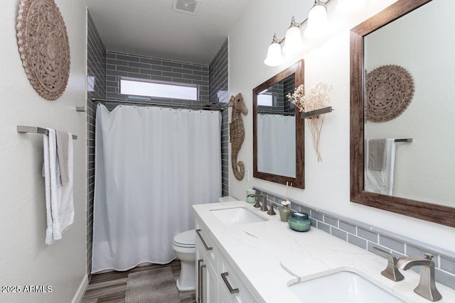 bathroom featuring vanity, wood-type flooring, toilet, and walk in shower