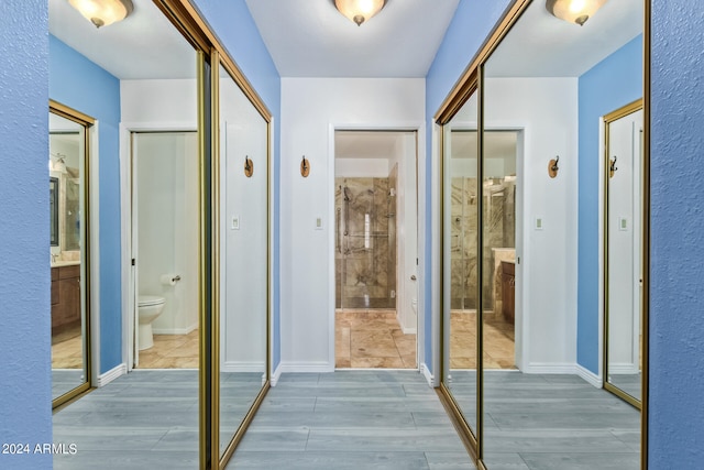 bathroom featuring toilet, a tile shower, and vanity