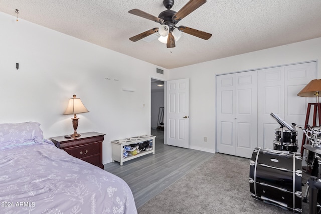 bedroom with a textured ceiling, ceiling fan, a closet, and hardwood / wood-style flooring