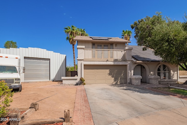 view of front of property with a balcony, a garage, and solar panels