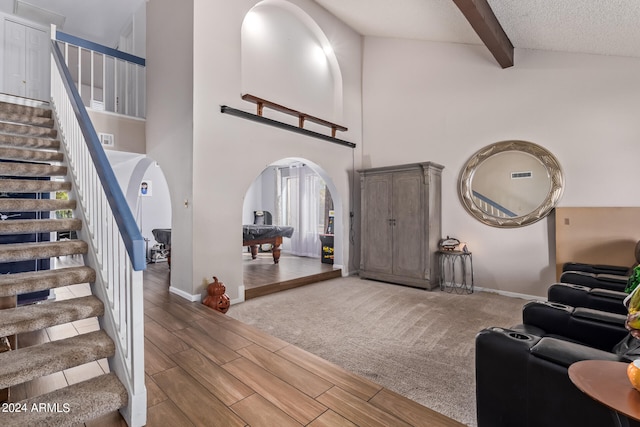 foyer with a textured ceiling, pool table, a high ceiling, and beamed ceiling