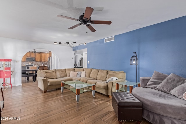 living room featuring ceiling fan and light hardwood / wood-style flooring