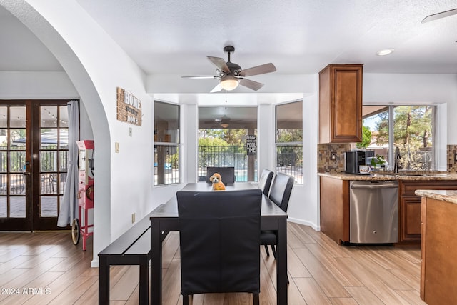 dining room with a textured ceiling, ceiling fan, and french doors