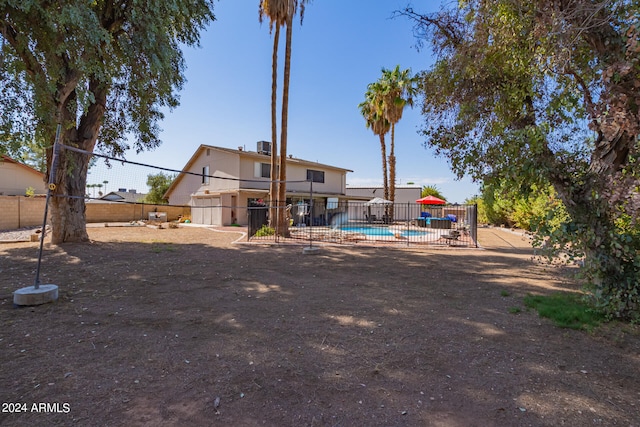 rear view of house featuring a fenced in pool