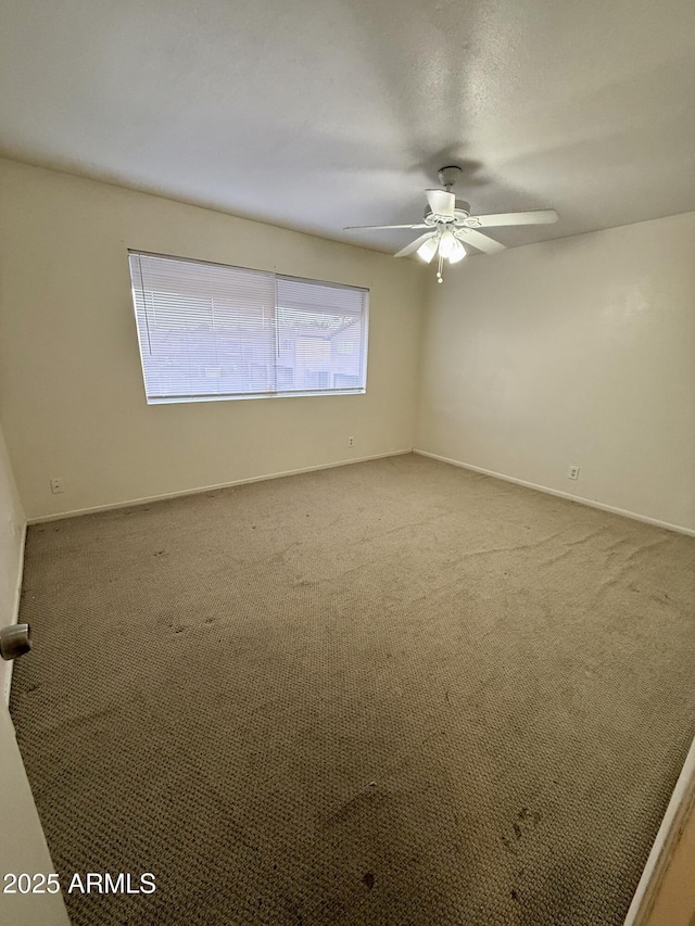 spare room with ceiling fan and carpet