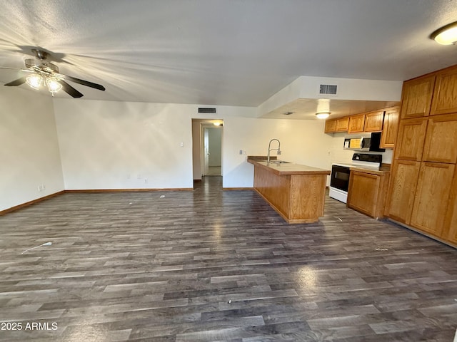 kitchen with kitchen peninsula, ceiling fan, dark wood-type flooring, white electric stove, and sink