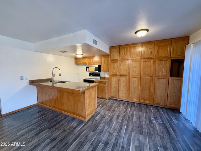 kitchen featuring kitchen peninsula, electric range, sink, tile counters, and dark hardwood / wood-style flooring