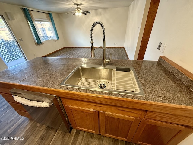 kitchen with ceiling fan, dark hardwood / wood-style flooring, stainless steel dishwasher, and sink