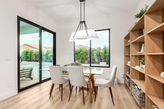 dining space with light wood-type flooring, plenty of natural light, and baseboards