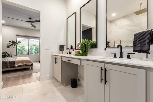 full bath with ceiling fan, double vanity, a shower, ensuite bath, and baseboards