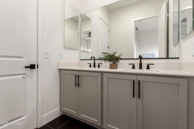 bathroom featuring double vanity, tile patterned floors, and baseboards