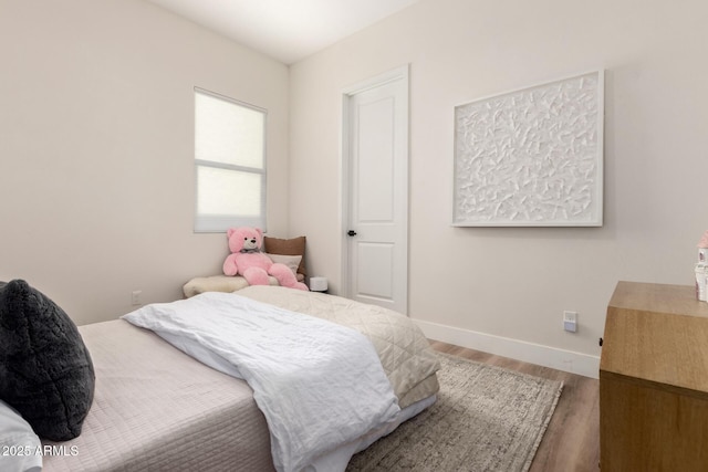 bedroom featuring wood finished floors and baseboards