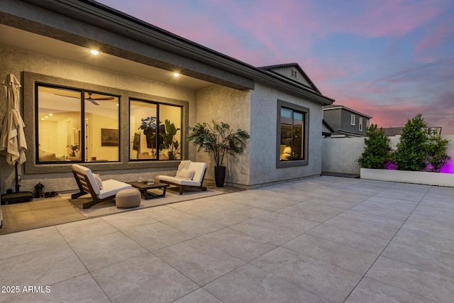 patio terrace at dusk featuring an outdoor hangout area