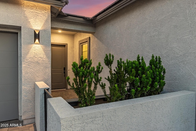entrance to property featuring stucco siding