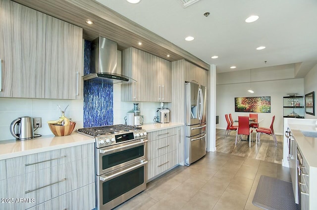 kitchen featuring wall chimney exhaust hood, modern cabinets, and stainless steel appliances