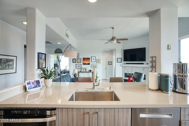 kitchen featuring light countertops, visible vents, open floor plan, and a sink