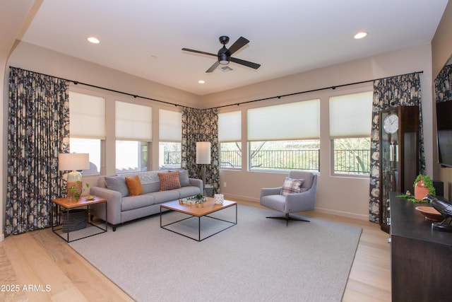 living room with ceiling fan and light wood-type flooring