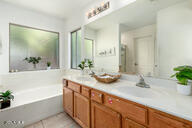 bathroom with tile patterned floors, a bathing tub, and vanity