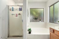 bathroom featuring separate shower and tub and vanity