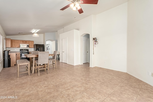 tiled dining space featuring ceiling fan and lofted ceiling