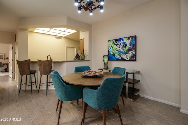 dining space featuring an inviting chandelier and hardwood / wood-style flooring