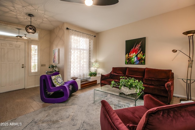 living room featuring wood-type flooring and ceiling fan