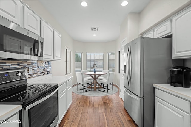 2834 E Devon Ct, Gilbert, AZ 85296 - kitchen with stainless steel appliances, white cabinets, wood finished floors, decorative backsplash, and recessed lighting