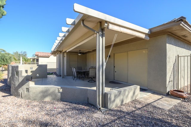 back of property featuring ceiling fan and a patio