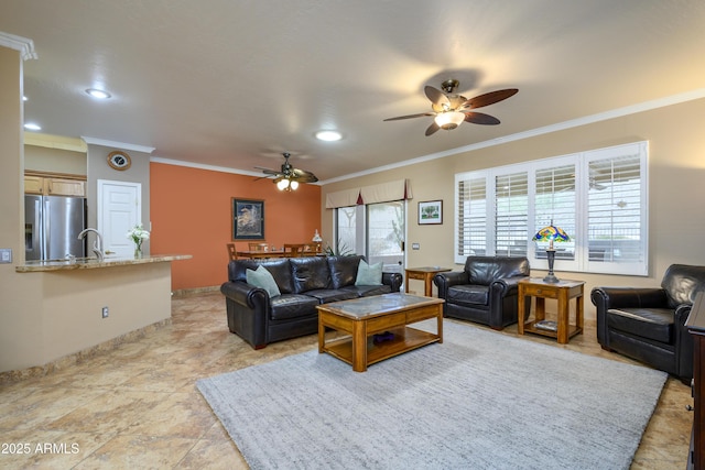 living room featuring ceiling fan, sink, and ornamental molding