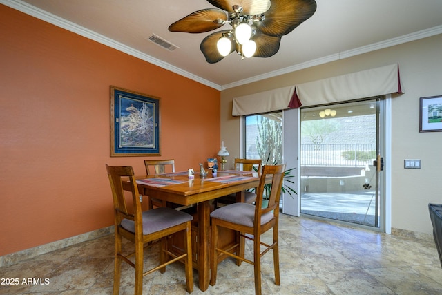 dining area with ceiling fan and crown molding